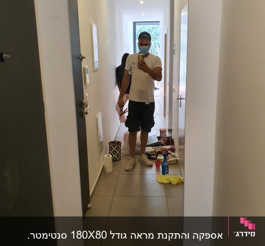 מראה גדולה במסדרון עם השתקפות של אדם